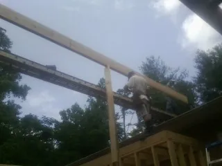 Carpenter setting a ridge beam over a new addition frame — Ice Dam Removal by Roofing Brothers in Mount Sidney