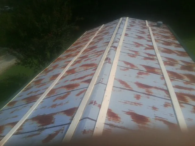 Rusted metal roof panels with new wood purlins before replacement — Storm Damage Roof Repair in Mount Sidney by Roofing Brothers